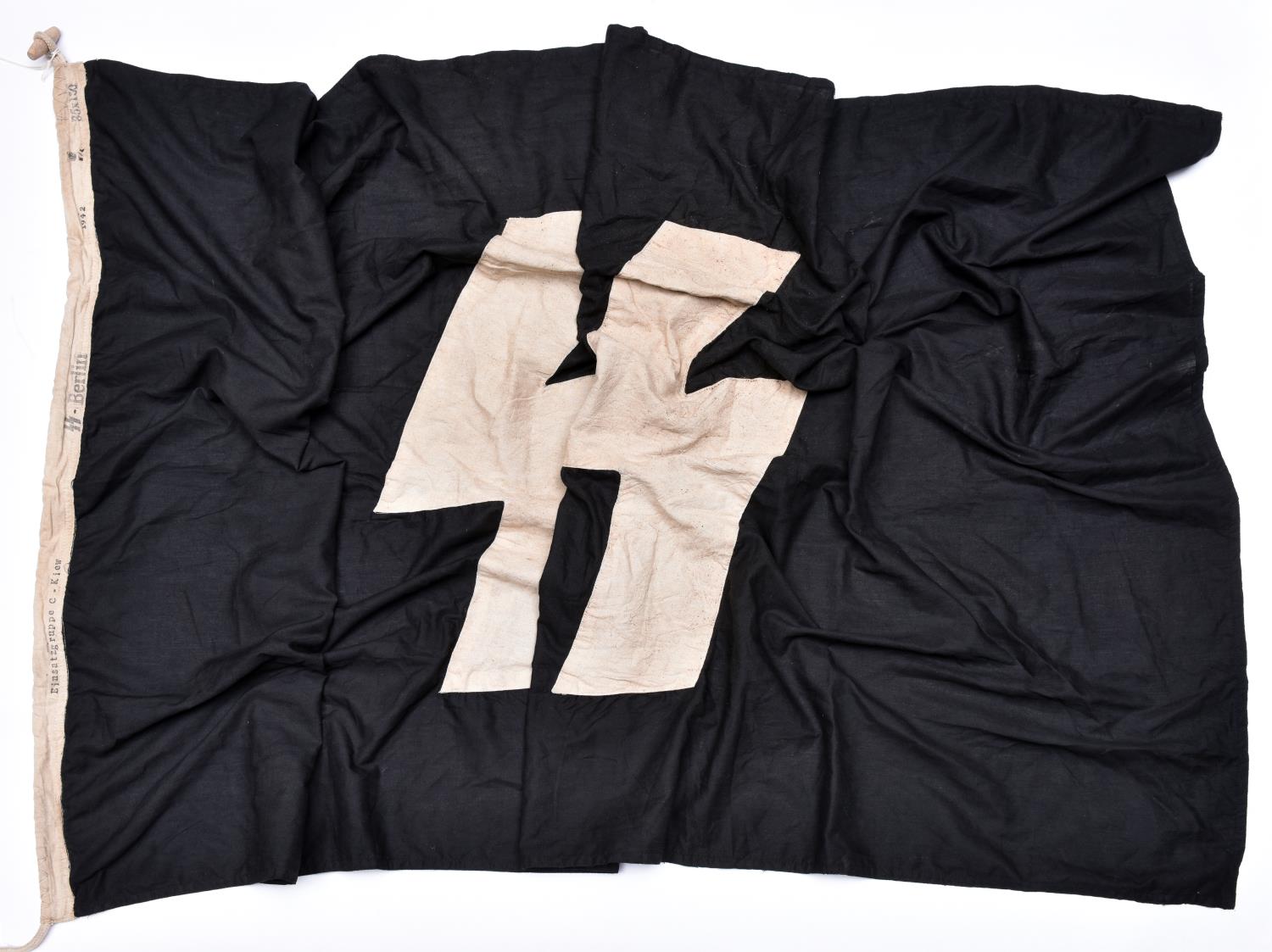 A Third Reich SS flag, black cloth with white runes, 85 x 150mm, edge stamped "Einsatzgruppe -