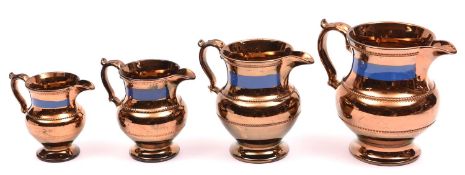 4x mid-19th Century graduating Lustreware jugs in copper and blue finish with beeding decoration.