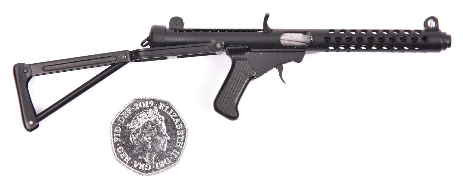 A well detailed miniature model of a sten gun, with folding skeleton butt, finely chequered pistol