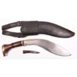 A kukri, probably mid 20th century, blade 11", with brass mounted polished wood hilt, in its leather