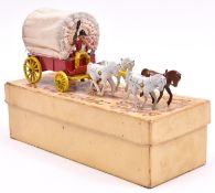 A Benbros Qualitoy Buffalo Bill's Covered Wagon. In red with yellow shafts and wheels, canvas top, 4