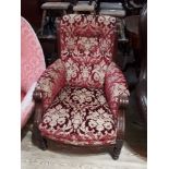 A late Victorian armchair with scroll arms and damask upholstery.