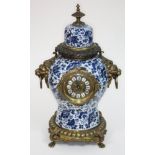A 19th century French faience blue and white and gilt metal mounted clock, with lion mask handles to