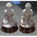 A pair of Indian carved ivory lotus seated buddha, each on stained wood base, circa 1900, height