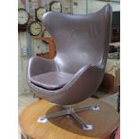 A brown leather egg chair in the manner of Arne Jacobsen for Fritz Hansen. Condition - swivel and