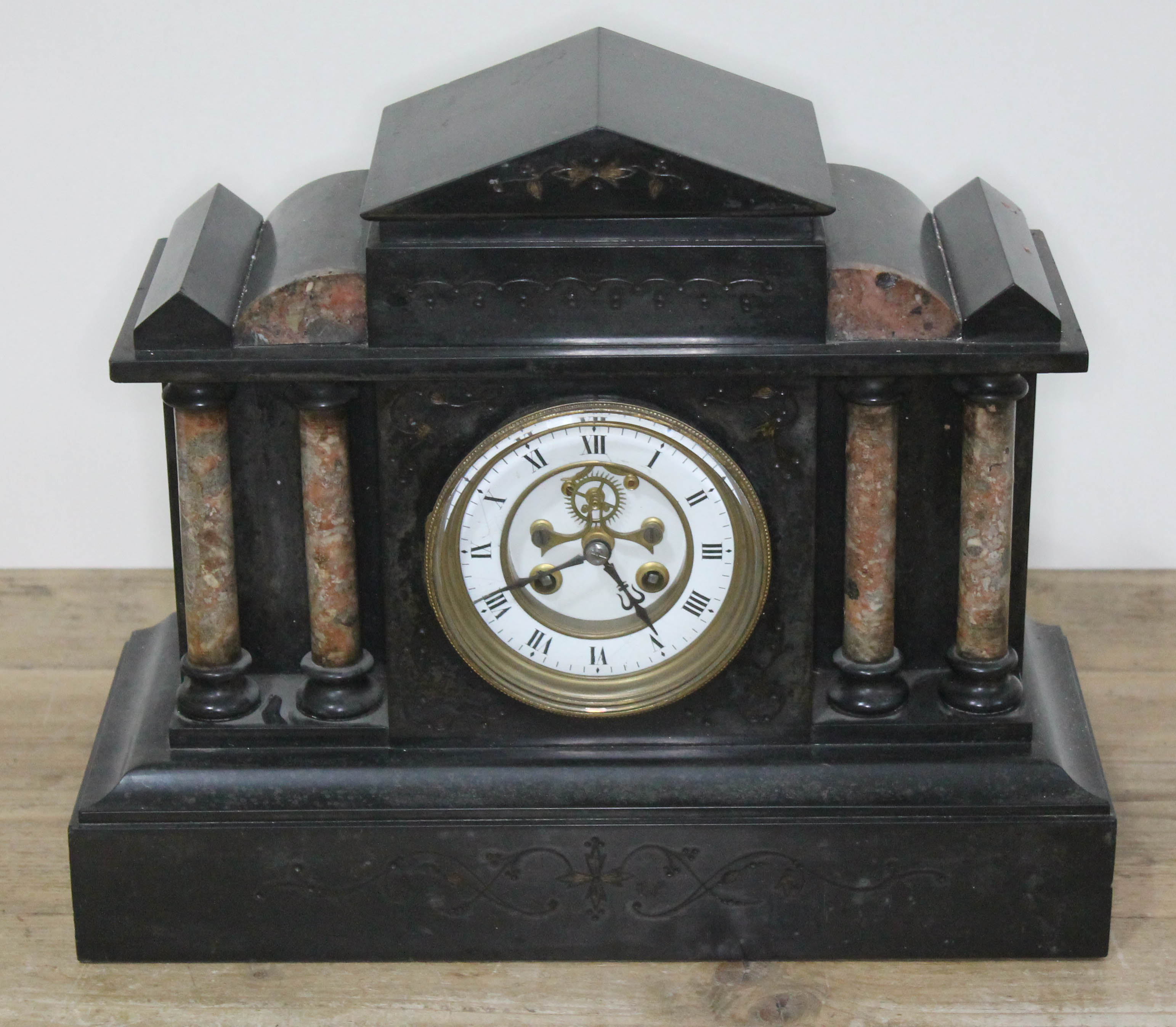 A Victorian black slate and marble mantel clock with visible brocot escapement, length 37cm.