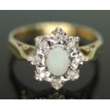 A hallmarked 18ct gold diamond and precious opal cluster ring, the head measuring approx. 11mm x