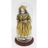 A bisque headed doll, numbered 3200 to back of neck, length 36cm, under glass dome.
