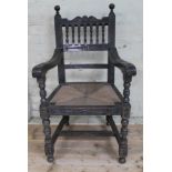 an 18th century style profusely carved oak armchair with rush seat, height 111cm.