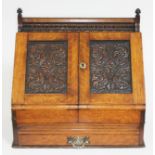 A Victorian oak stationary box with carved panelled doors and lower drawer, height 36cm.