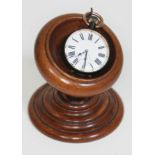 A gun metal over sized pocket watch on oak watch stand, the watch having Roman numerals and