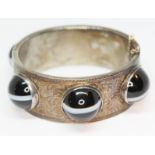 A Victorian Scottish bright cut engraved bangle set with six banded agate cabochons, the cabochons
