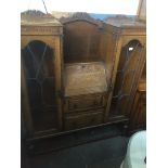 An oak 1930s/40s display cabinet with center bureau. Live bidding available via our website, if