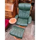 An Ekornes Stressless green leather adjustable swivel armchair and matching stool. Live bidding