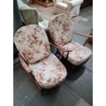 A pair of Ercol low armchairs with fleur de lys backs Live bidding available via our website, if you