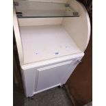 A small white cabinet with glass shelves Live bidding available via our website, if you require P&