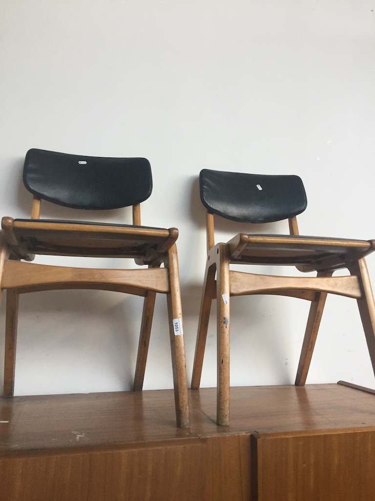 A pair of mid 20th century chairs with black rexene upholstery. Live bidding available via our