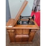 Victorian singer sewing machine (1891) with treadle in wooden unit. In working order. Live bidding