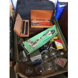 A box of miscellaneous items including stapler, glass paraffin lamps, magnet, long arm stapler,