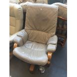 A light brown leather swivel armchair - base raised. Live bidding available via our website, if