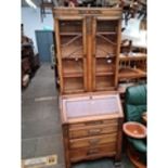 An oak bureau bookcase, h194cm w75cm, d41cm. Live bidding available via our website, if you