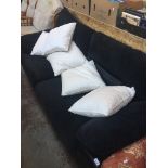 A black upholstered three seater sofa with additional white/cream cushions Live bidding available