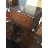 An oak sewing cabinet with sewing items inside including cotton thread reels, scissors, hemming,