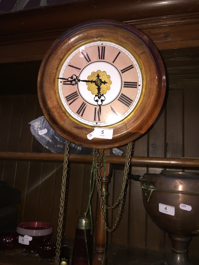 Wall clock with enameled face and weights.