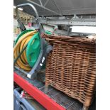Wicker fishing basket and garden reel with hose.