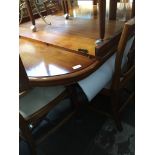 A large yew wood extending dining table and six chairs