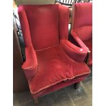 An oak framed and red upholstered wing back armchair