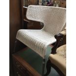 A modern white woven and metal framed armchair