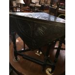 A carved oak drop leaf corner table