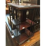 A mahogany revolving bookcase with shell inlay to top.