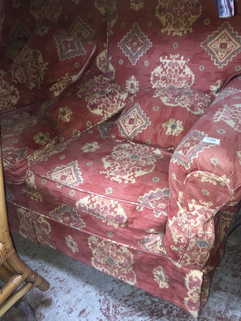 A crimson patterned two seater sofa