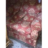 A crimson patterned two seater sofa