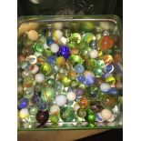 A tin of vintage marbles and bollies