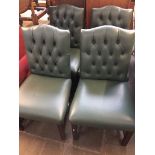 A set of four mahogany framed green buttoned andb studded leather high back chairs