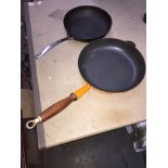 A volcano orange Le Creuset style pan and another.