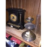 Ebonised wood clock and a brass oil lamp ( damaged ) with glass shade.