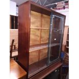 A bookcase with glass sliding doors.