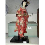 Geisha doll on wooden base and with box