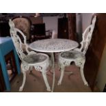 A white painted cast metal table and two chairs.