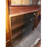 A bookcase with glass sliding doors.