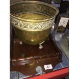 A brass bowl and a wooden spoon display rack