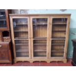 A glazed pine bookcase, length 195cm, depth 31cm & height 170cm.