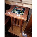 An oak plant stand with Art Nouveau inset tile, height 52cm.