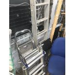 A small set of aluminium extending ladders and 3 sets of steps