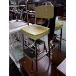 A retro Champion fold out step stool with yellow seat and back.