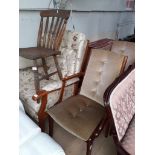 A pair of teak framed armchairs, an upholstered wing back armchair and a spindle back kitchen chair.